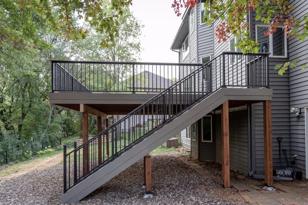 Side view of TimberTech deck stairs with black railing and gray side stringer.