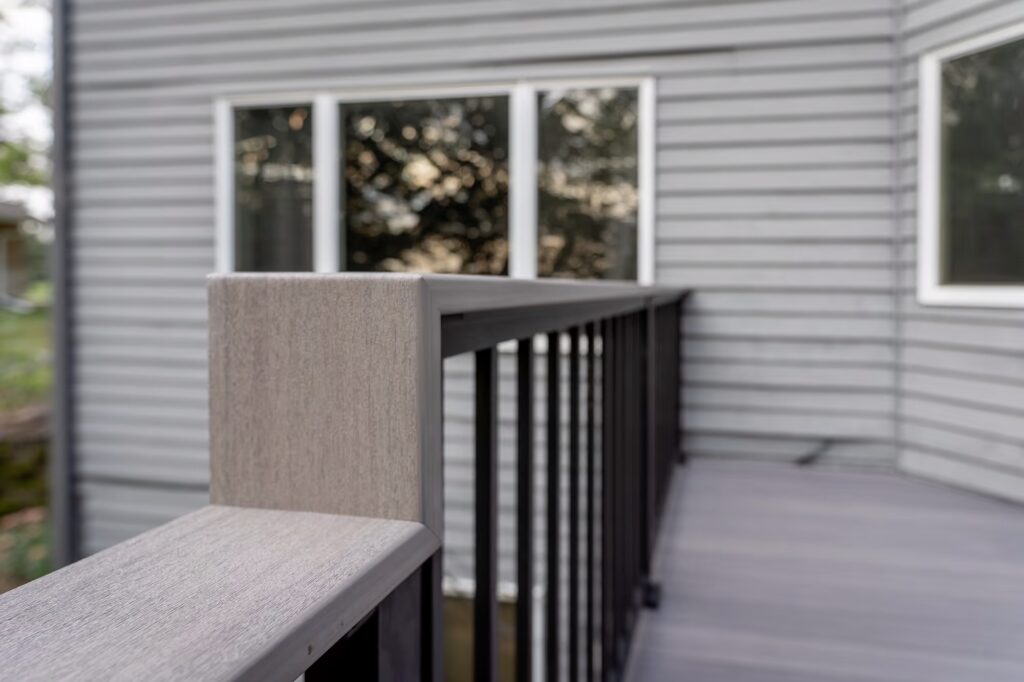 Custom aluminum deck railing with gray drink rail that steps down to match the raised platform on the deck. 