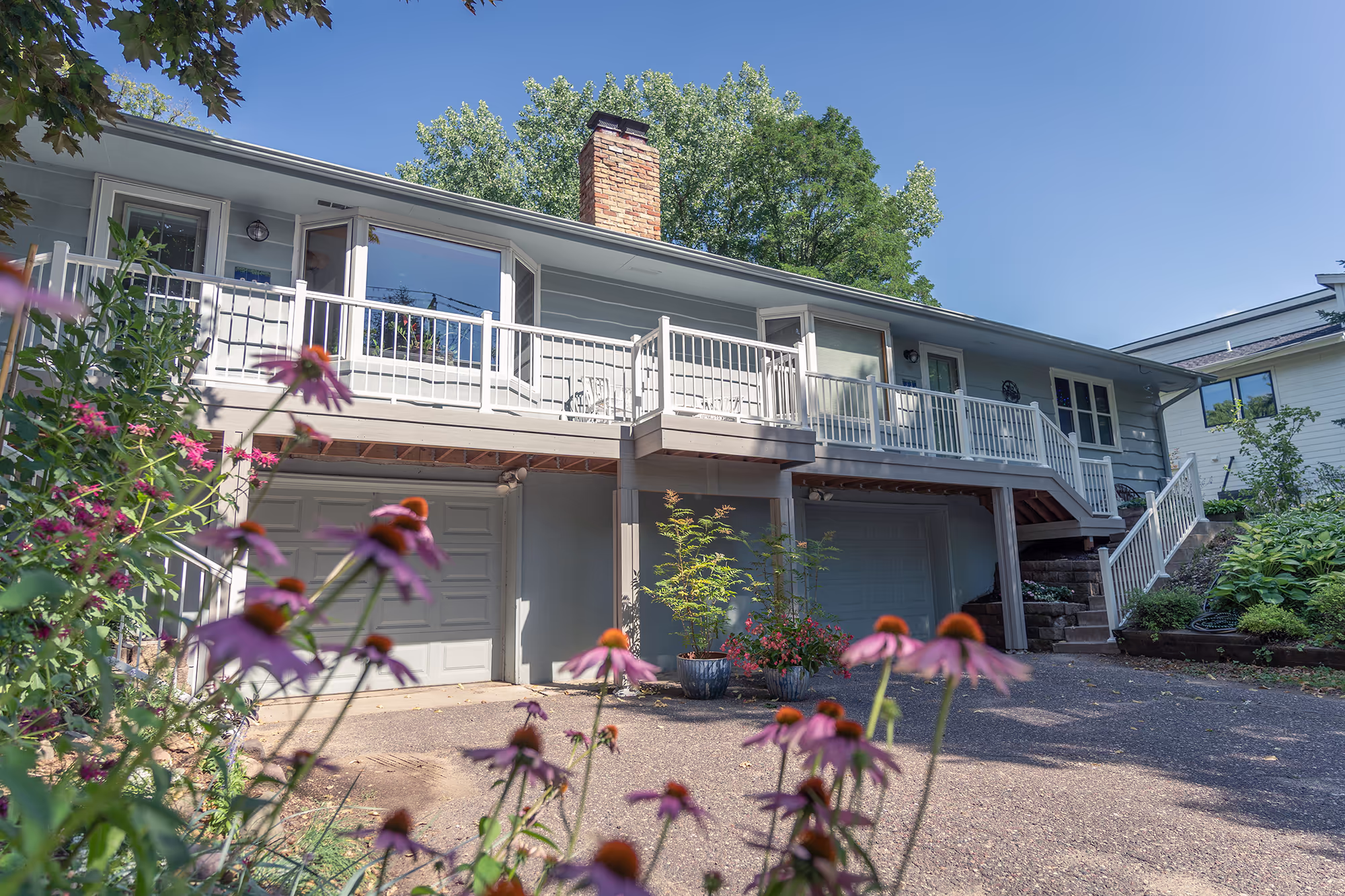 Low-maintenance deck spanning the front of two duplexes above their garages.