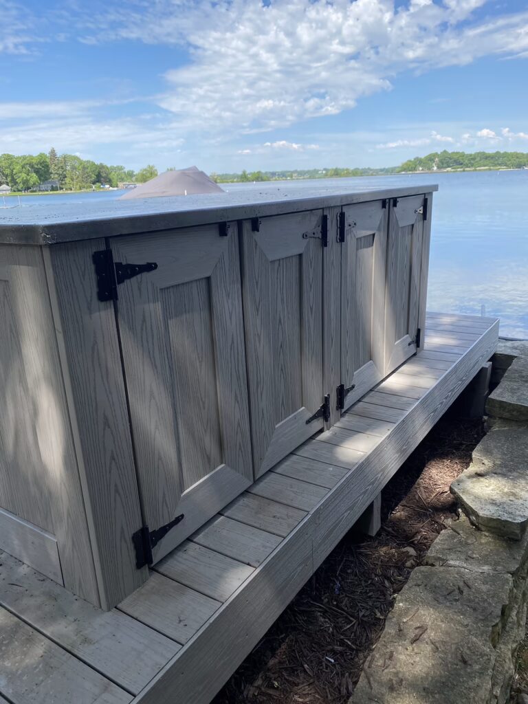 PVC deck storage cabinets in front of a lake. 