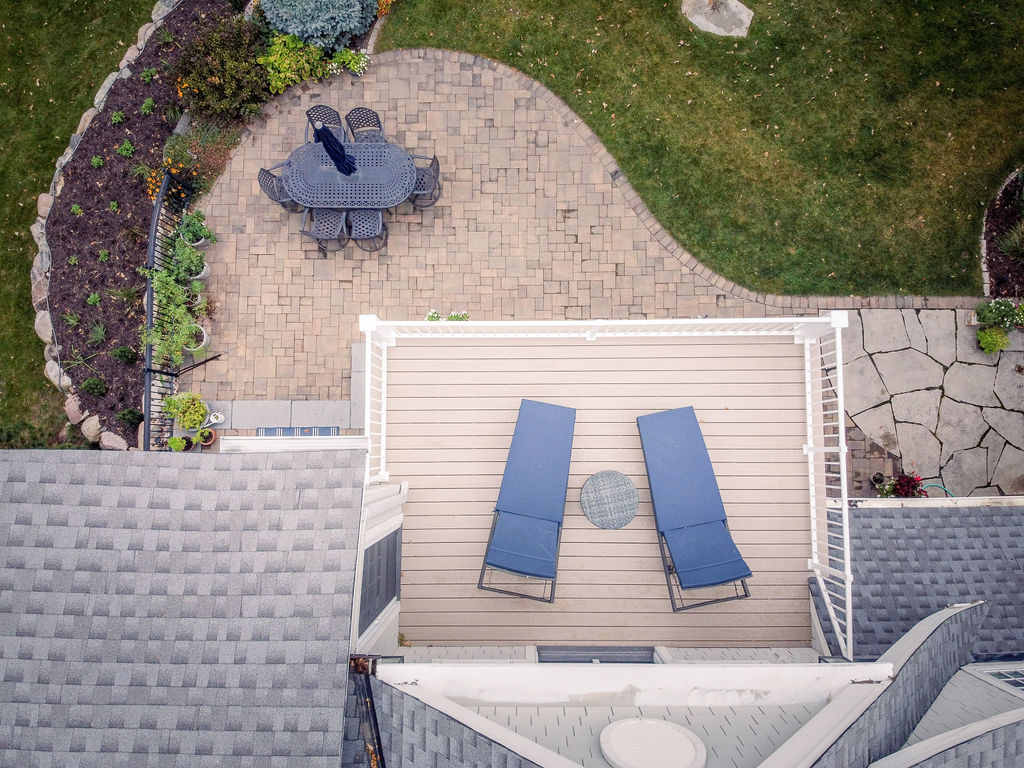 Top aerial view of PVC deck with two lounge chairs and curved patio below. 