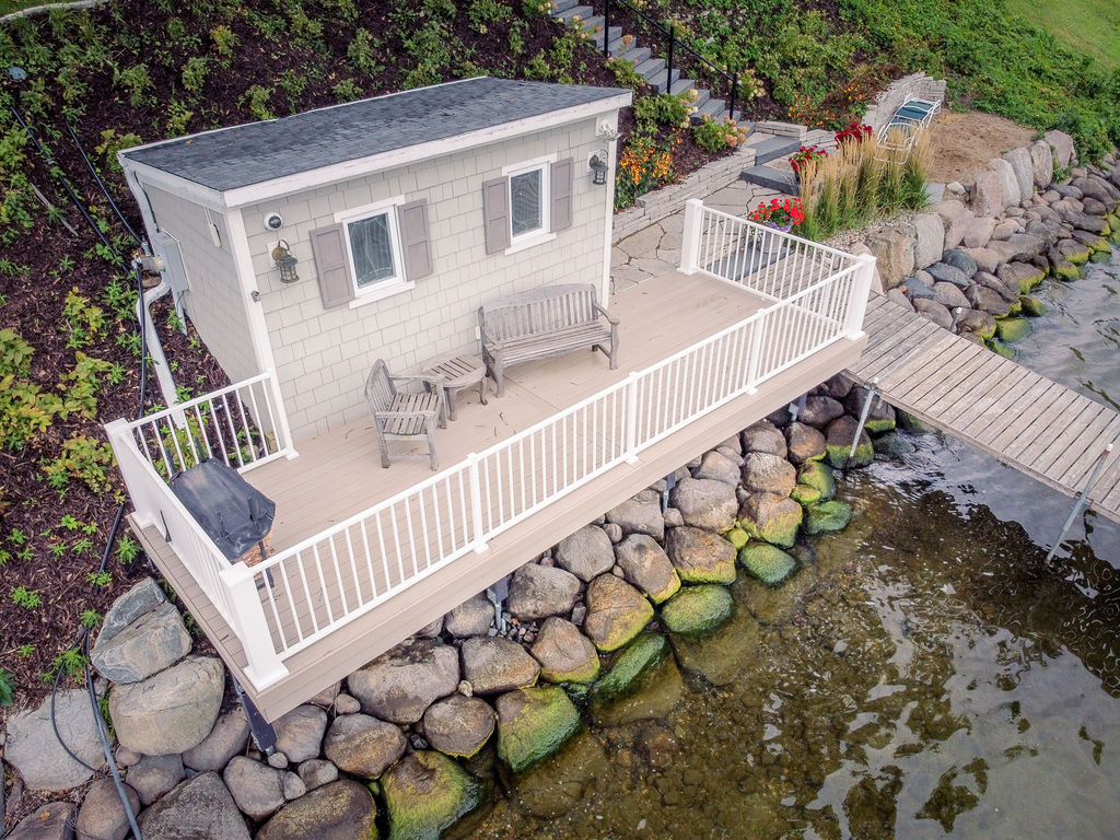 Aerial view of lakeshore boat house with PVC deck and white aluminum railing. 