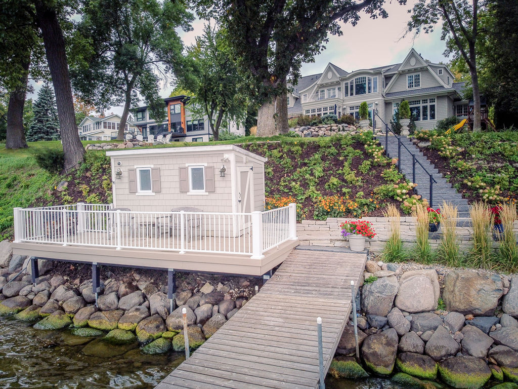 Minnesota boathouse on a lake with a low-maintenance deck and dock leading into the lake. 