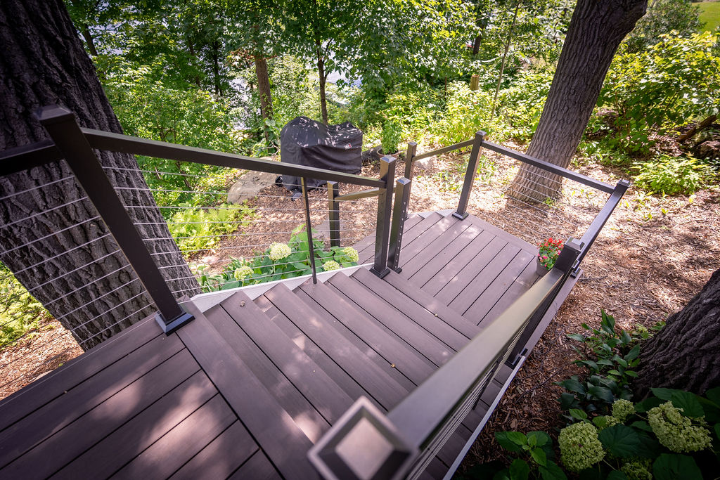 Top view of L-shaped deck staircase using TimberTech Advanced PVC and aluminum railing with horizontal cables.