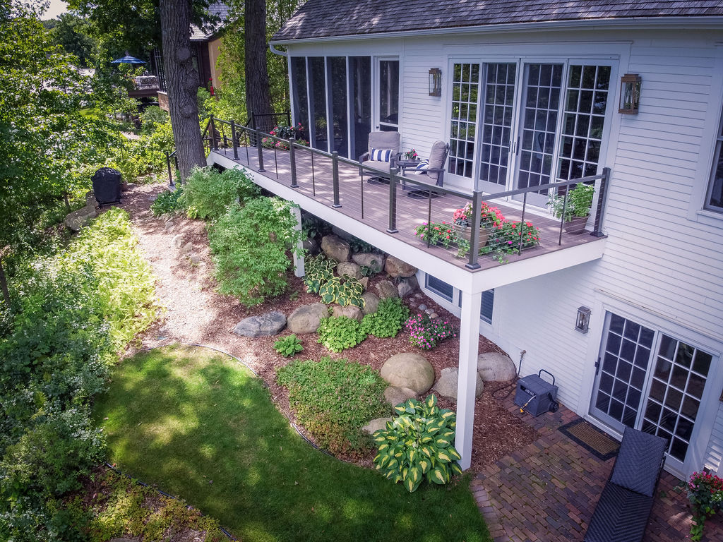 Aerial image of a low-maintenance deck on a house surrounded by tasteful landscaping.