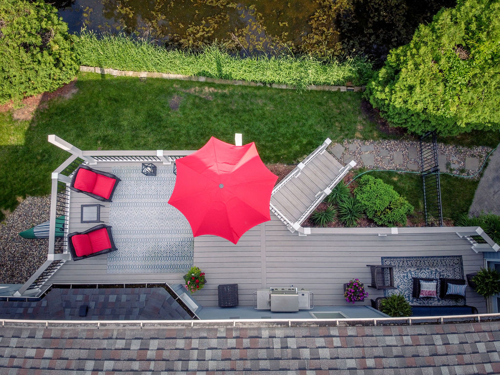 Top aerial view of TimberTech Advanced PVC deck in Boardwalk with red furnishing accents.