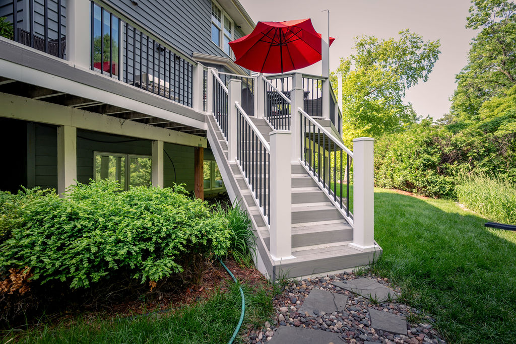Bottom of low-maintenance staircase landing on a slate and gravel walkway.