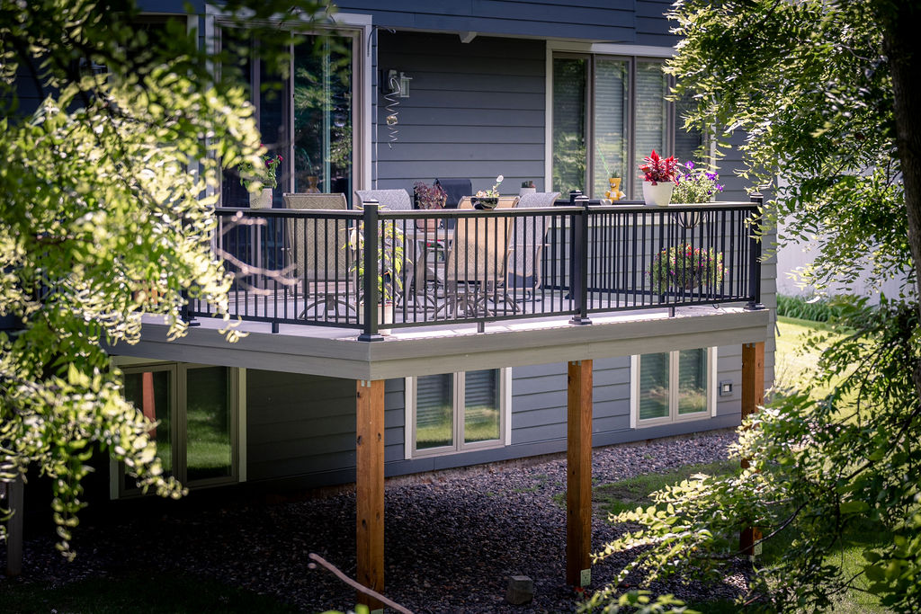 View of secluded second-story backyard deck as seen through tree branches.