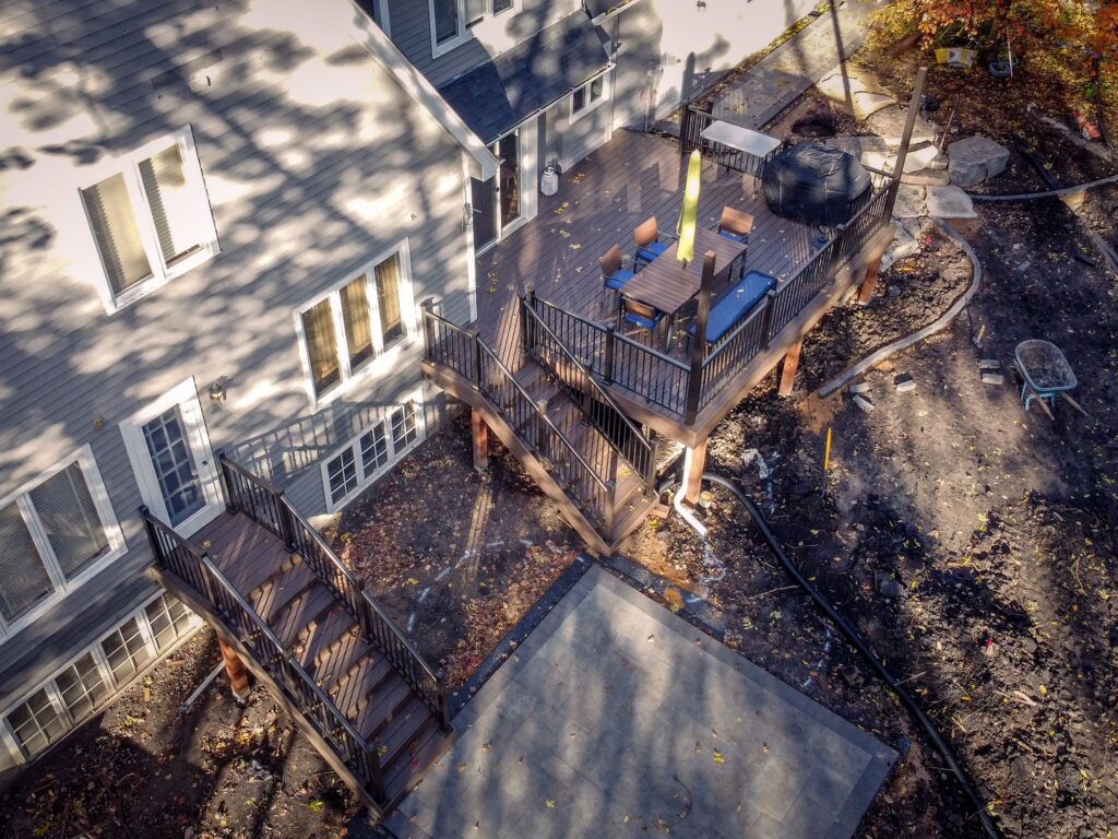 Aerial view of a low-maintenance deck with an additional staircase during the fall, surrounded by fallen leaves. 