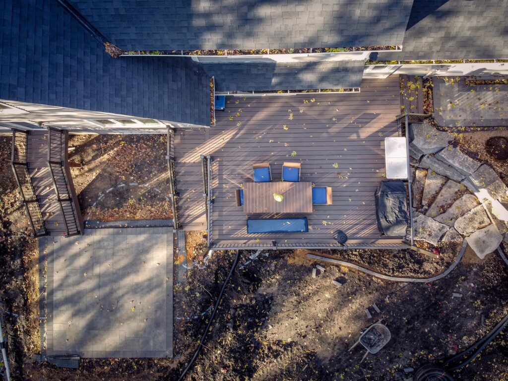 Aerial top-down view of a low-maintenance deck with an adjacent patio during the fall. 