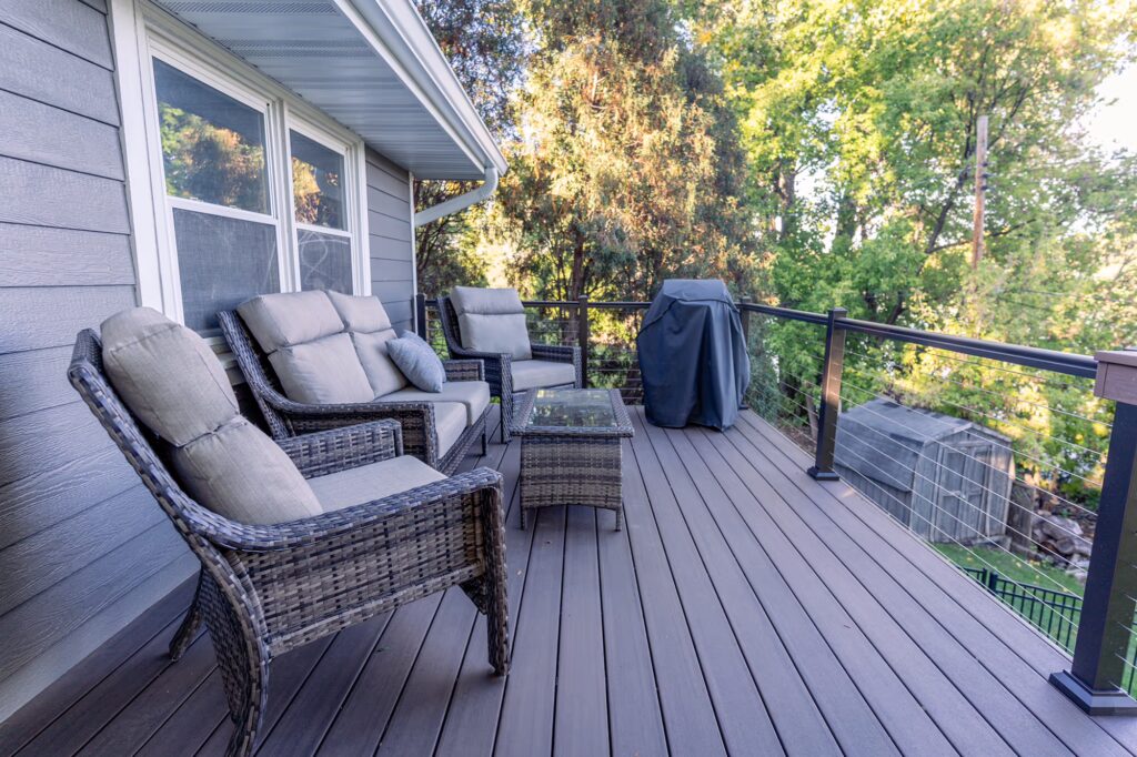 Composite deck with comfortable furnishings, surrounded by trees.