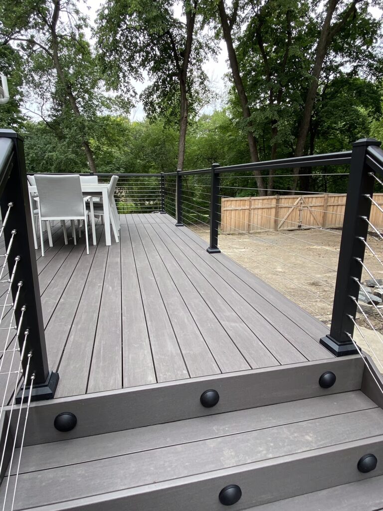 Low-maintenance deck stairs with riser lights and aluminum cable railing. 