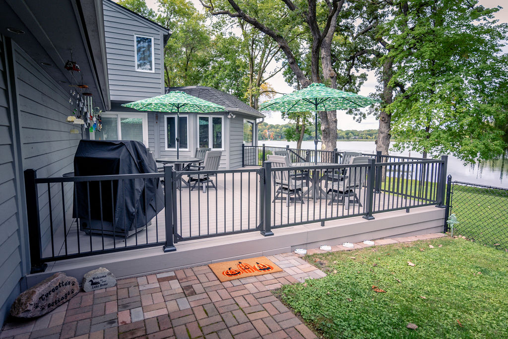 Side view of platform PVC deck with outdoor furnishings and a view of the lake behind it.