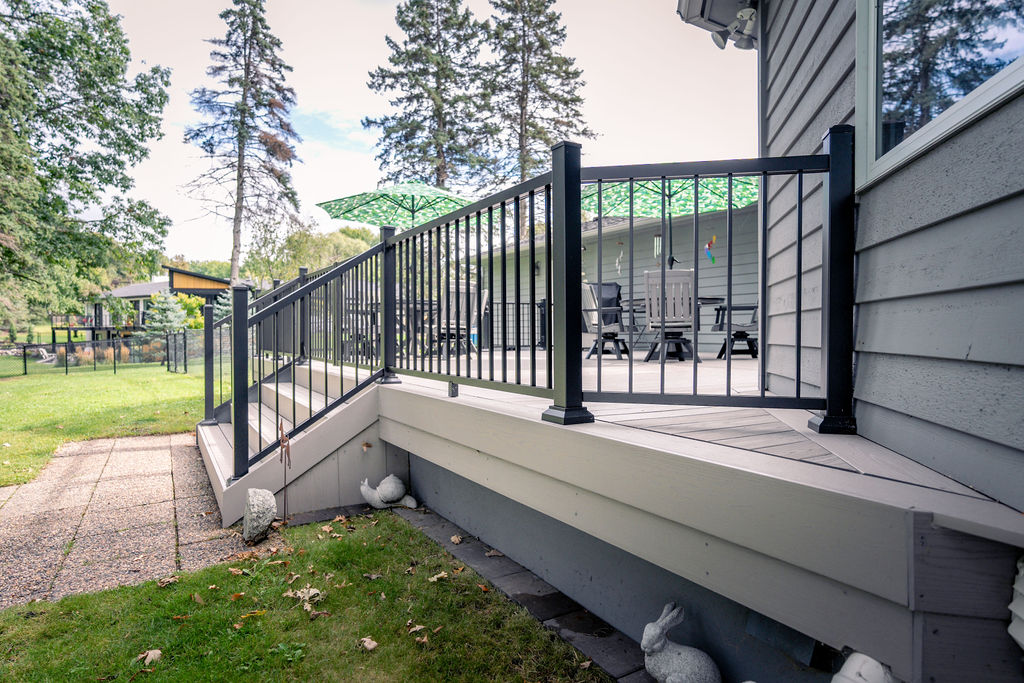 Side view of platform deck stairs with black aluminum railing and PVC decking from TimberTech.