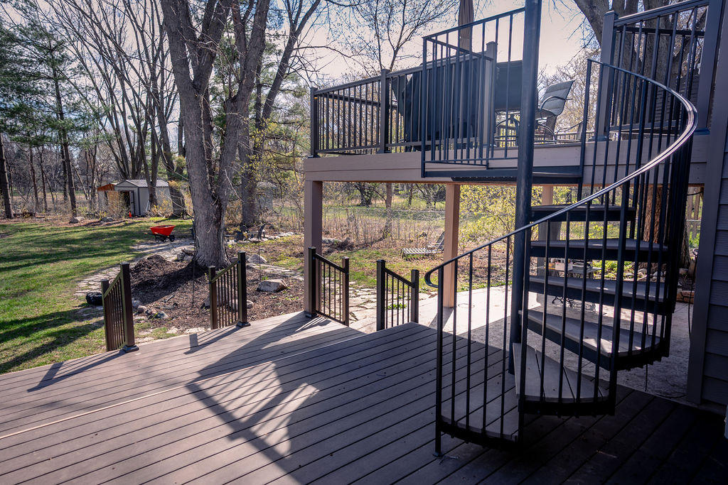 Low-maintenance deck with spiral staircase leading to upper level.