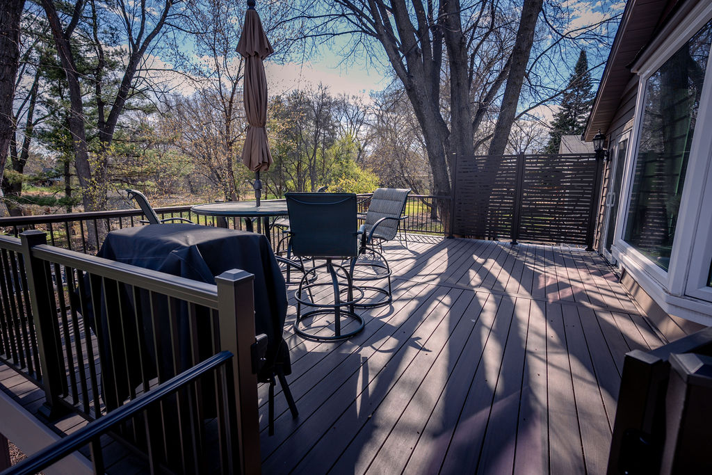 Top level of multi-level deck using TimberTech Advanced PVC decking and aluminum railing with integrated lights, and privacy panels.