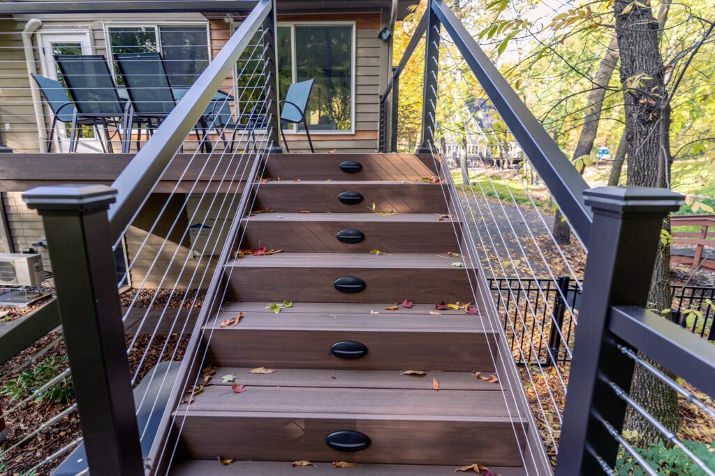 Upper portion of L-shaped staircase with cable railing and integrated lights. 