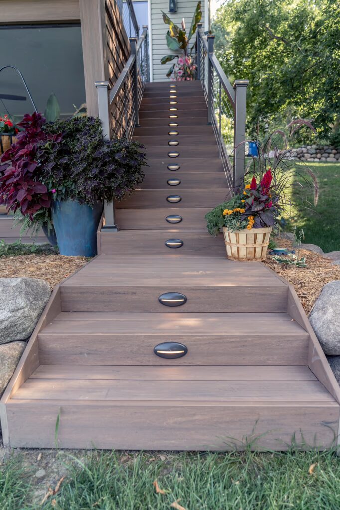 TimberTech Advanced PVC deck staircase with integrated riser lights and autumn decor.