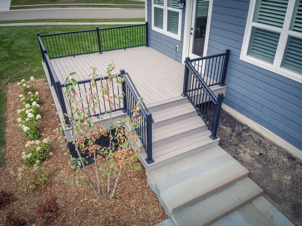 Aerial view of a low-maintenance deck leading down to a paver patio. 