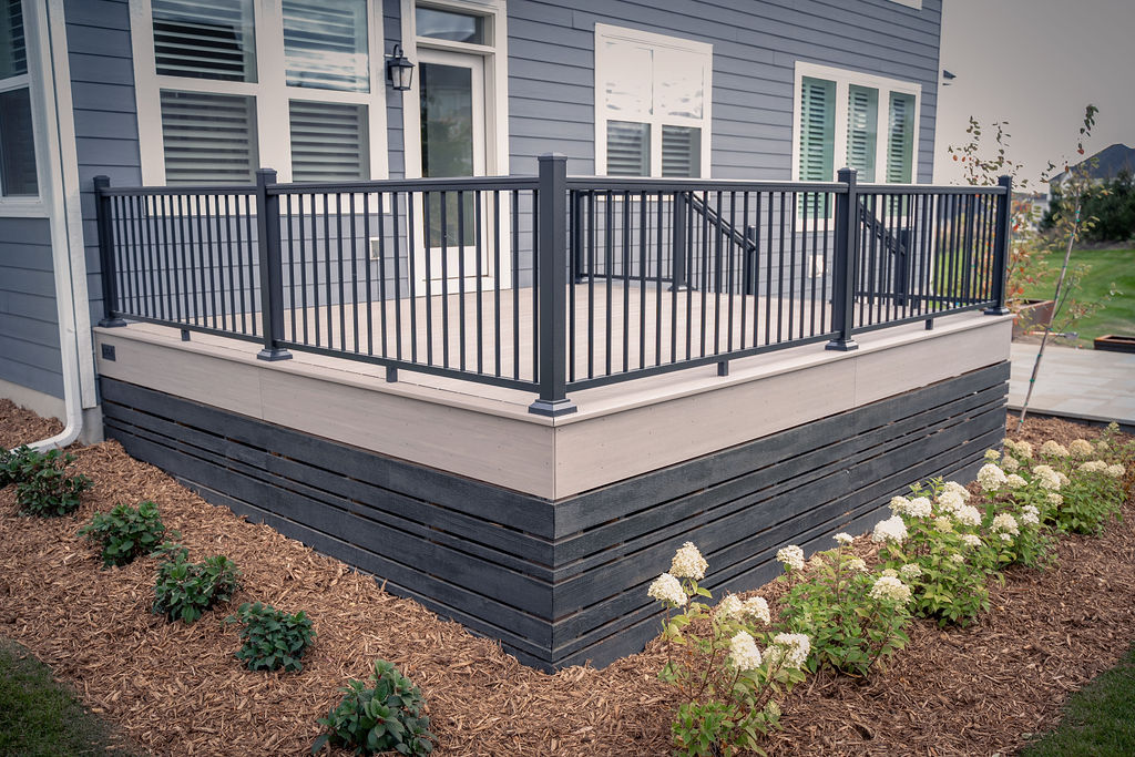 Corner of a low-maintenance deck using TimberTech engineered products and new landscaping. 